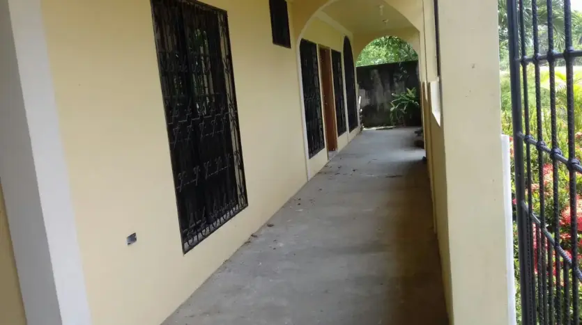Side corridor with barred windows of the house in Colonia Milenium, Tela