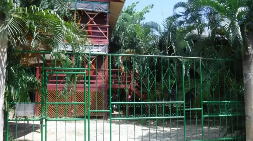 Entrada con portón del estudio Hidden Pearl en West End, Roatán