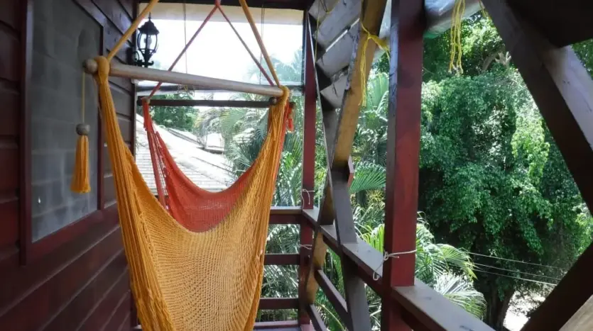 Balcón con silla colgante en el estudio Hidden Pearl, West End, Roatán