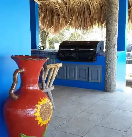 Outdoor kitchen with grill under a palapa at Playa Vida, La Ceiba