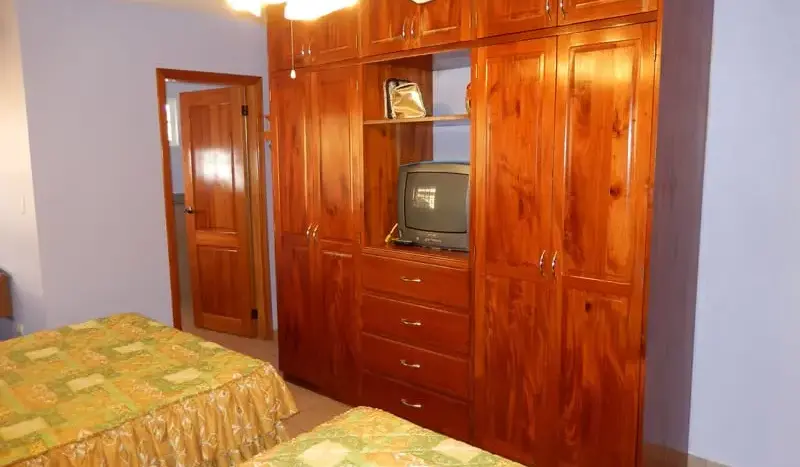 Habitación con clóset de madera en la villa de Palma Real, La Ceiba