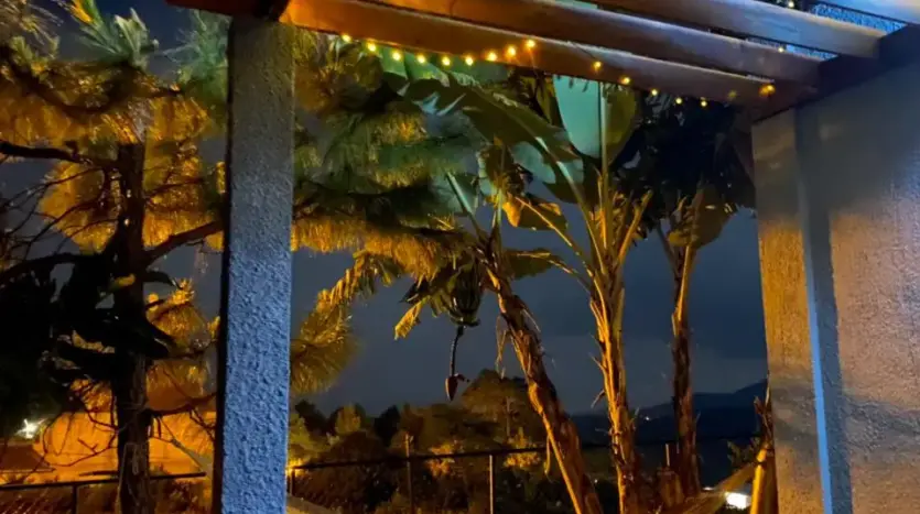 Pérgola iluminada con hamaca de noche en la casa de Marcala