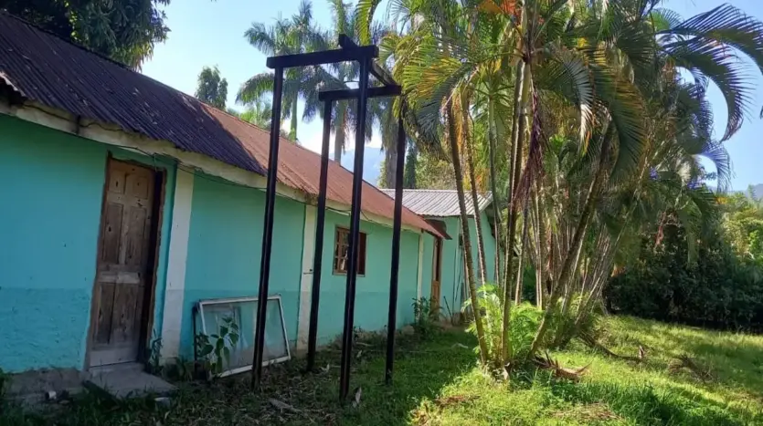 Turquoise house with tropical trees in Piedra Pintada, La Ceiba