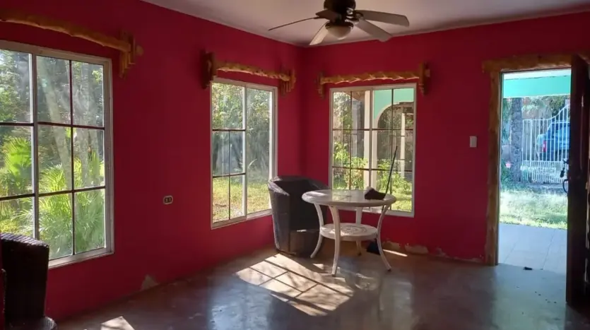Red room with large windows in the house in Piedra Pintada, La Ceiba