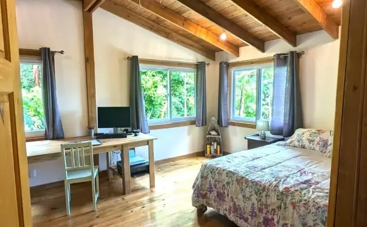 Bedroom with desk and wood beams at Flamingo House, Roatan