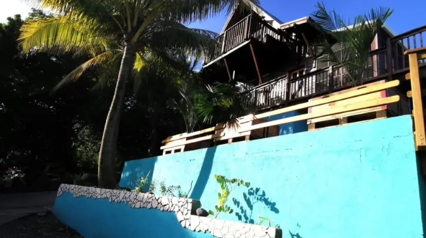 Exterior of Flamingo House with decks and palms, First Bight, Roatan
