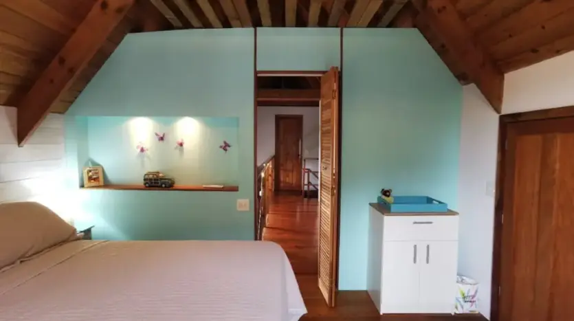Bedroom with turquoise wall at Flamingo House, First Bight, Roatan