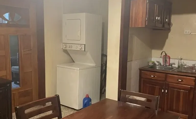 Dining table and laundry area in an apartment in Puerto Cortes