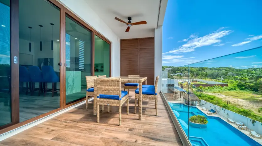 Terraza del condominio en Acqua di Mare con mesa de comedor y vista a la piscina del resort