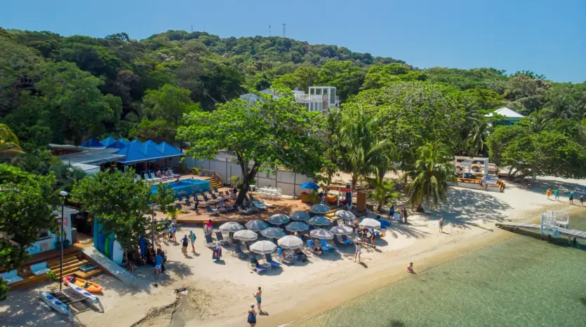 Playa con sombrillas entre West End y West Bay