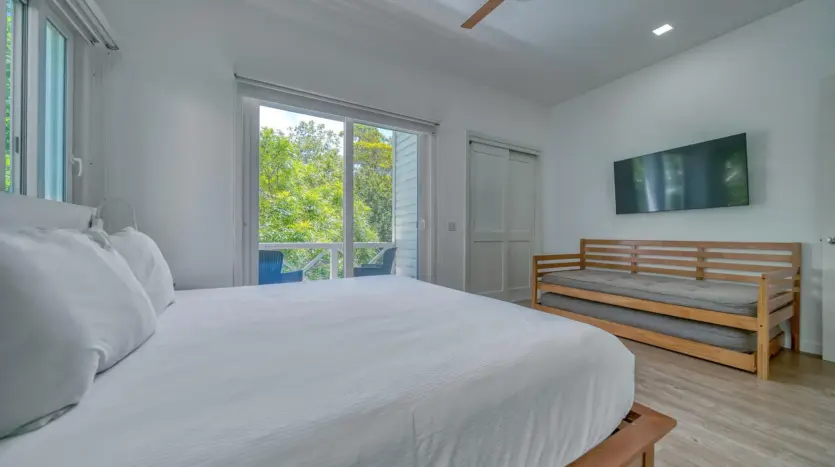 Habitación que se abre a un balcón entre los árboles