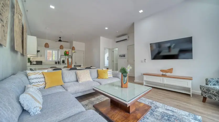 Sala abierta con sofá seccional y TV