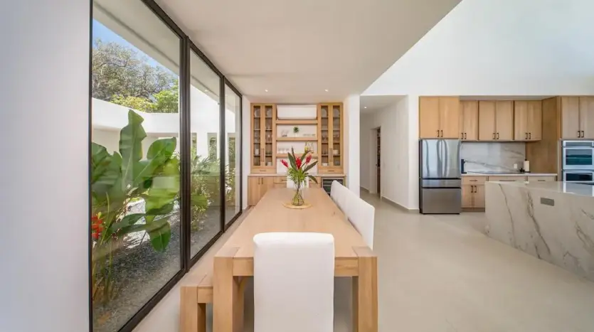 Long dining table between glass walls