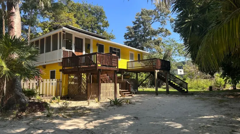 Yellow island cabana with wooden decks and stairs, Seadancer, Sandy Bay