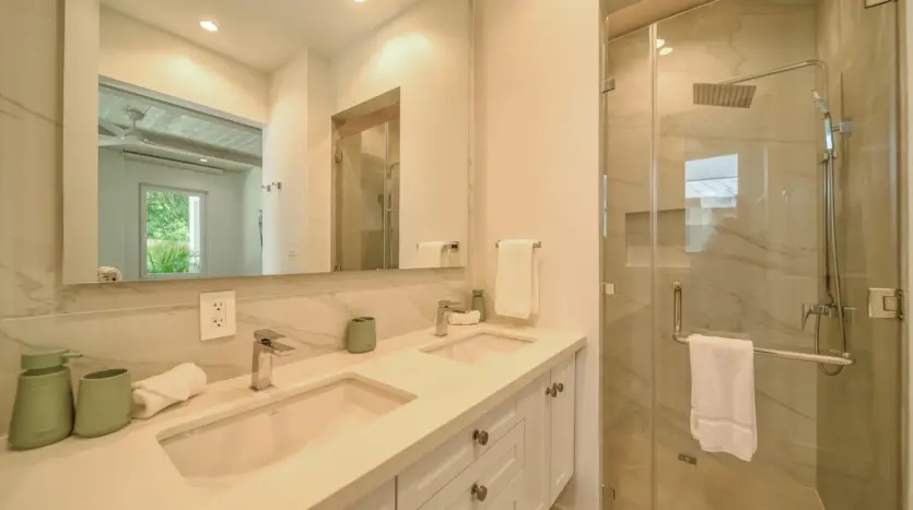 Guest bathroom with glass shower, sample unit